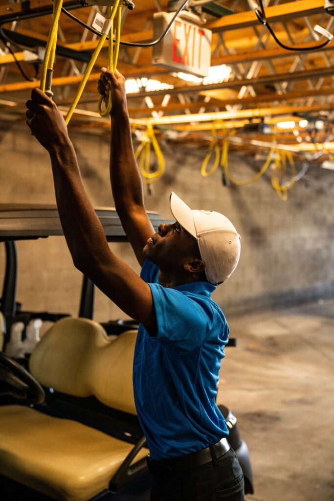 Man working with tools in a workshop filled with smoke.