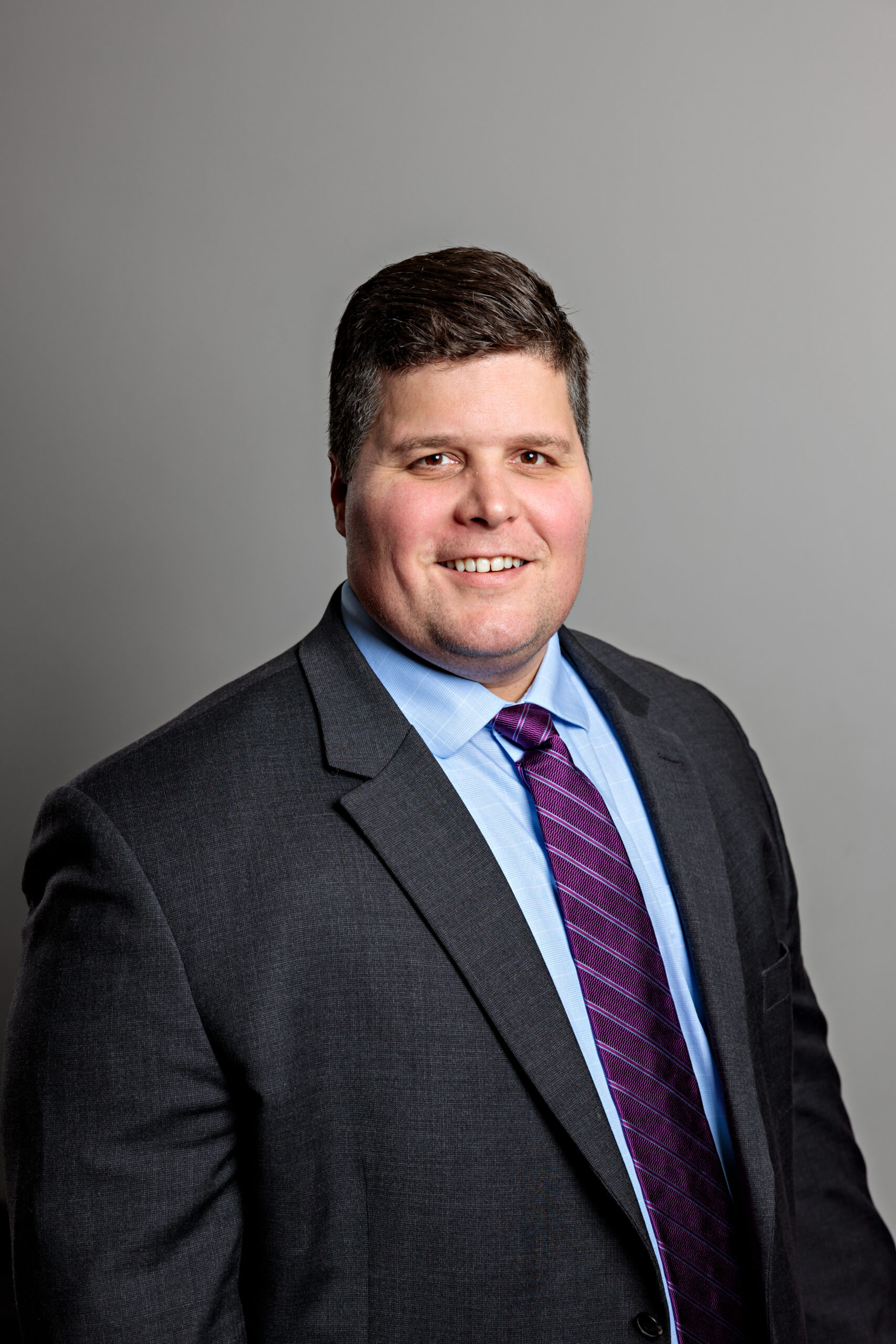 Professional portrait of a man in a suit and tie.